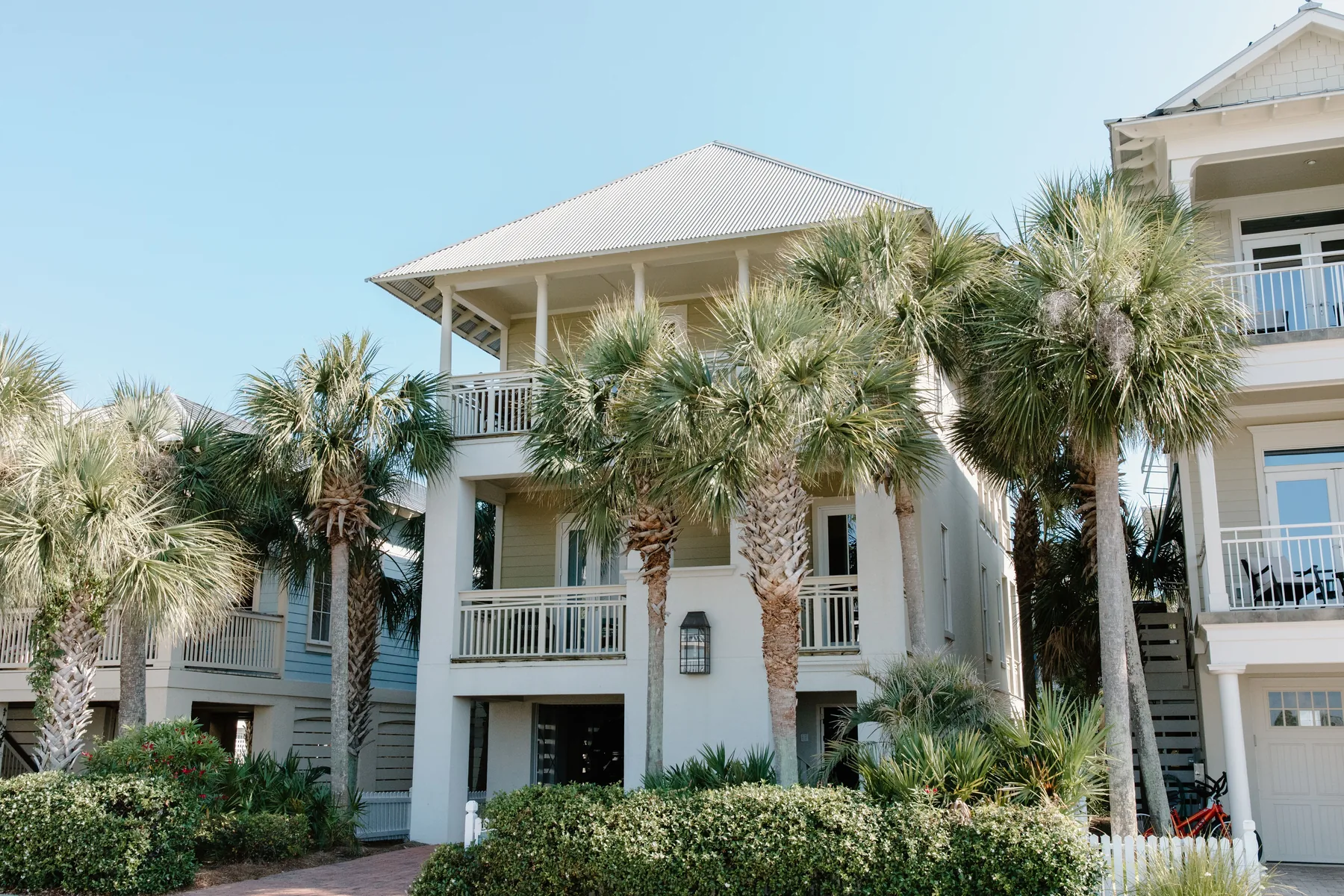 Coastal home exterior surrounded by palm trees.